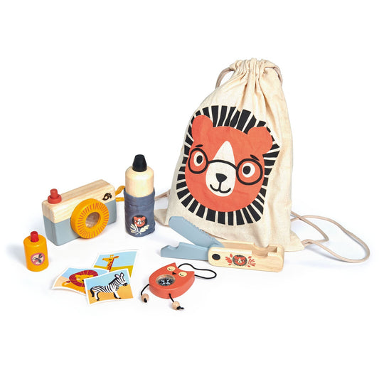 Cotton drawstring bag with hand-painted lion graphic next to wooden compass, camera, penknife, water bottle, and bug spray