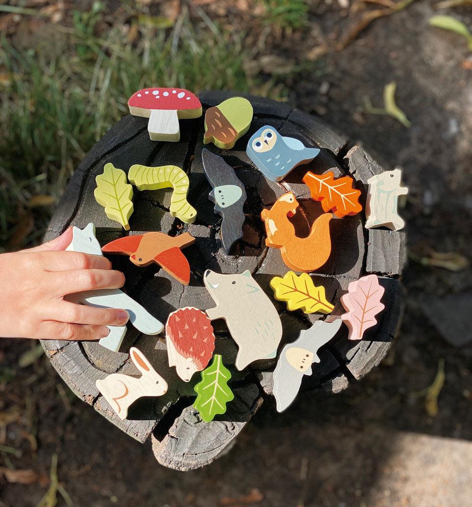 Child arranging the stacking forest animals on the beech tree trunk